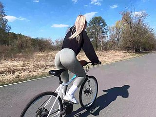 Ciclista rubia le muestra a su compañero melocotón a su pareja y folla en un parque público